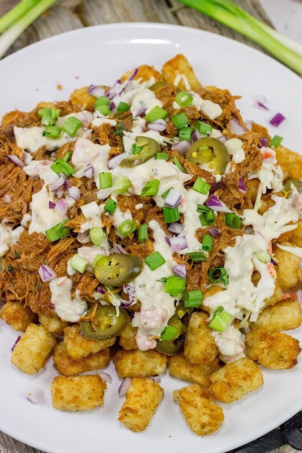Kick off BBQ season the right way! These Pulled Pork Totchos are topped with pulled pork, cole slaw and pepper jack queso. This delicious appetizer will be the hit of the party!