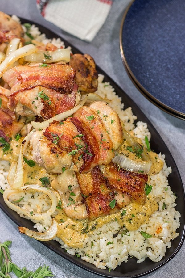 These Bacon-Wrapped Chicken Thighs are served over seasoned rice with a Dijon cream sauce.  Sounds fancy, right?  But this recipe came out of your own kitchen!