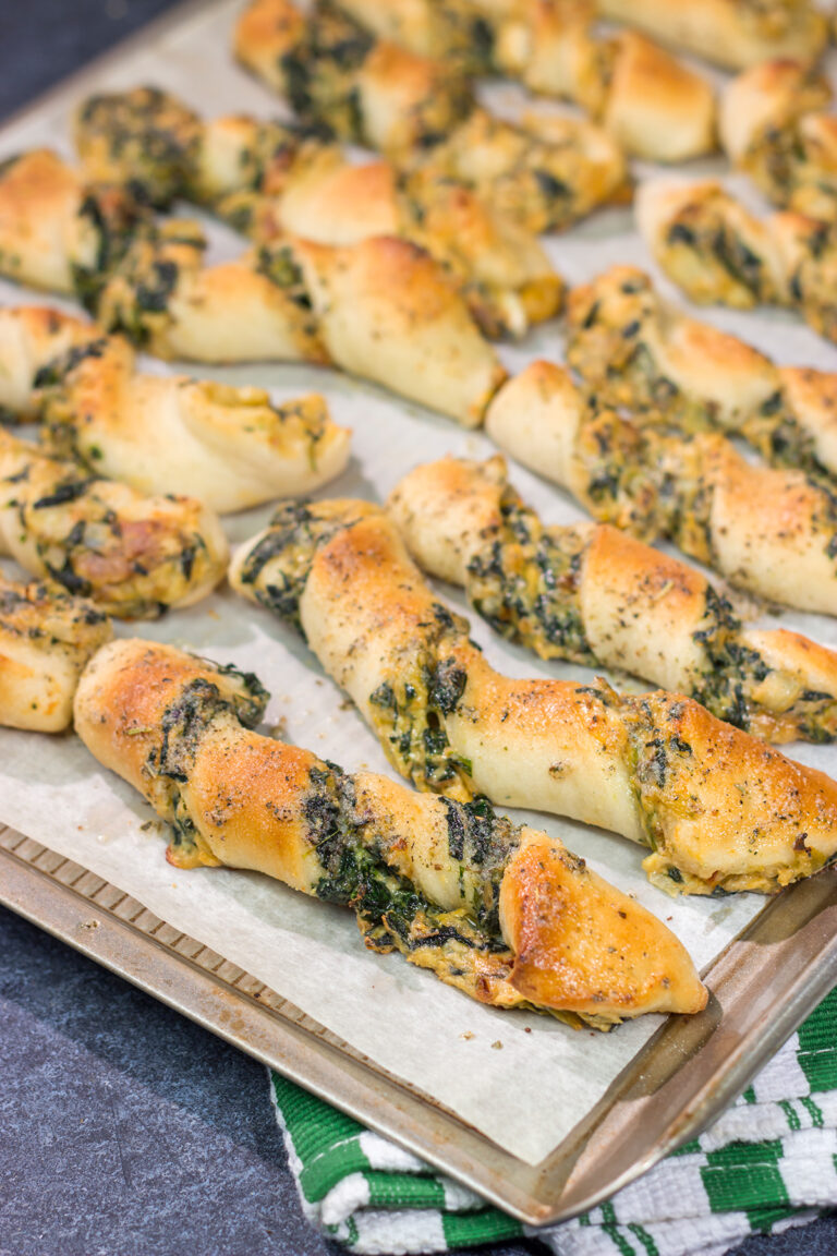 Looking for a tasty gameday appetizer? These Spinach Artichoke Breadsticks are a combination of garlic knots + spinach artichoke dip. They're delicious!