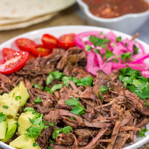 This Slow Cooker Mexican Shredded Beef recipe is tender, juicy and delicious! It's perfect for tacos, burritos or soups and stews. Make a batch tonight, and you'll have meals for the week!