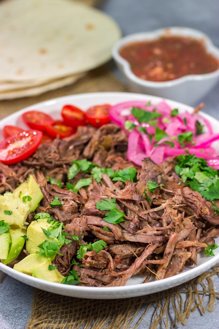 This Slow Cooker Mexican Shredded Beef recipe is tender, juicy and delicious! It's perfect for tacos, burritos or soups and stews. Make a batch tonight, and you'll have meals for the week!