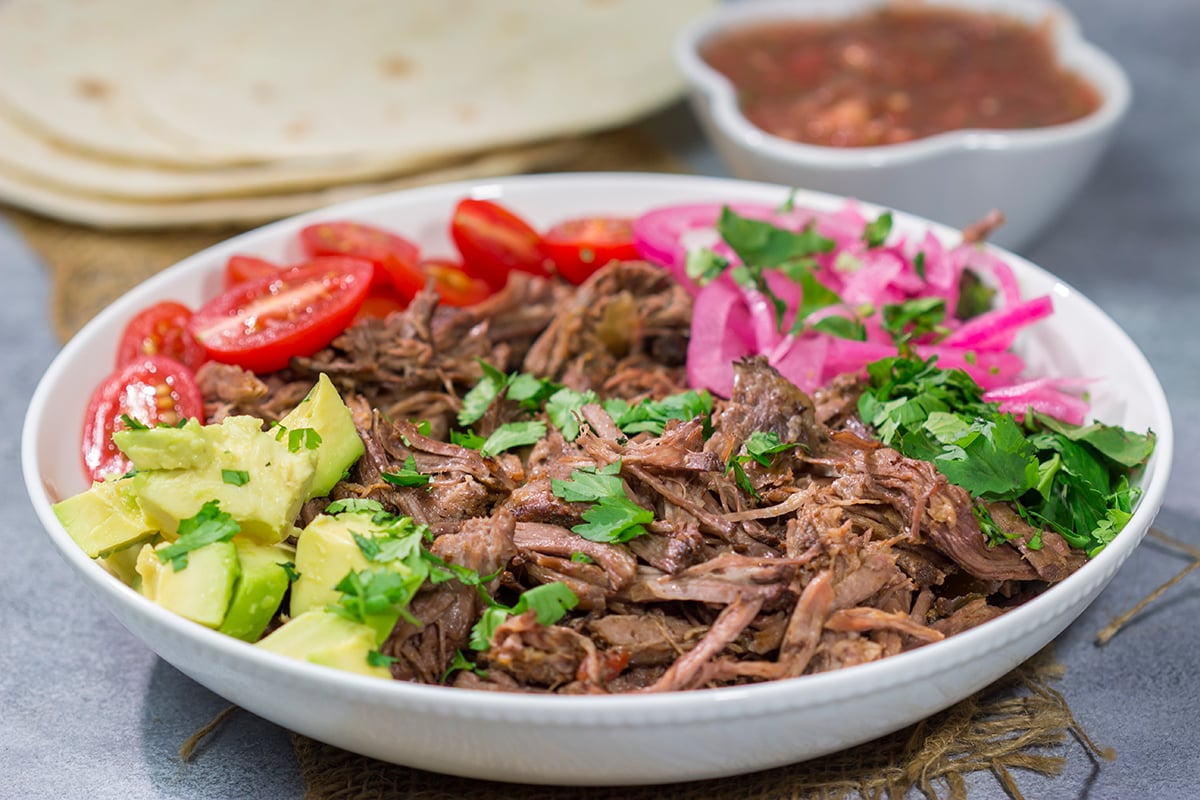 This Slow Cooker Mexican Shredded Beef recipe is tender, juicy and delicious! It's perfect for tacos, burritos or soups and stews. Make a batch tonight, and you'll have meals for the week!
