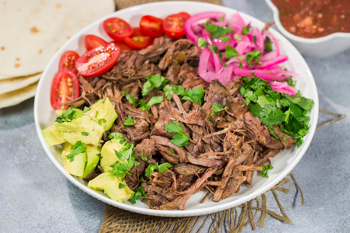 This Slow Cooker Mexican Shredded Beef recipe is tender, juicy and delicious! It's perfect for tacos, burritos or soups and stews. Make a batch tonight, and you'll have meals for the week!