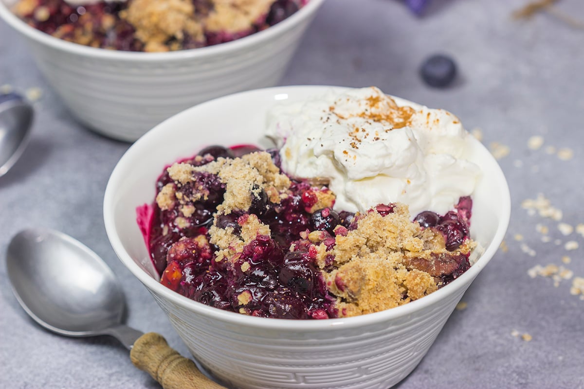 This classic Blueberry Crisp recipe features a juicy berry filling topped with a crispy oat streusel. It's the perfect dessert for warm summer evenings!