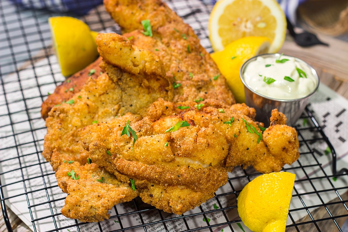 This Fried Catfish features a crispy cornmeal crust over tender catfish filets. Add in a squeeze of lemon and some homemade tartar sauce, and you've got a delicious fish fry recipe!