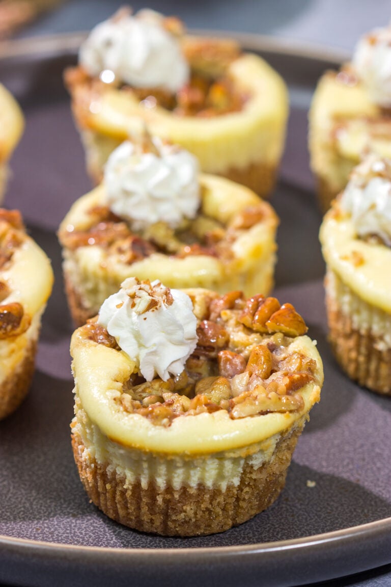 These Mini Pecan Pie Cheesecakes combine creamy cheesecake with crunchy pecan pie topping. This bite-sized dessert is perfect for holiday gatherings!