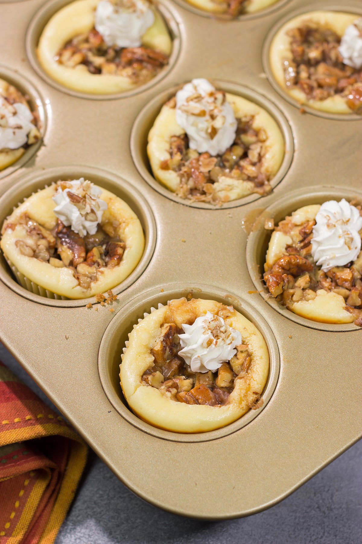 These Mini Pecan Pie Cheesecakes combine creamy cheesecake with crunchy pecan pie topping. This bite-sized dessert is perfect for holiday gatherings!