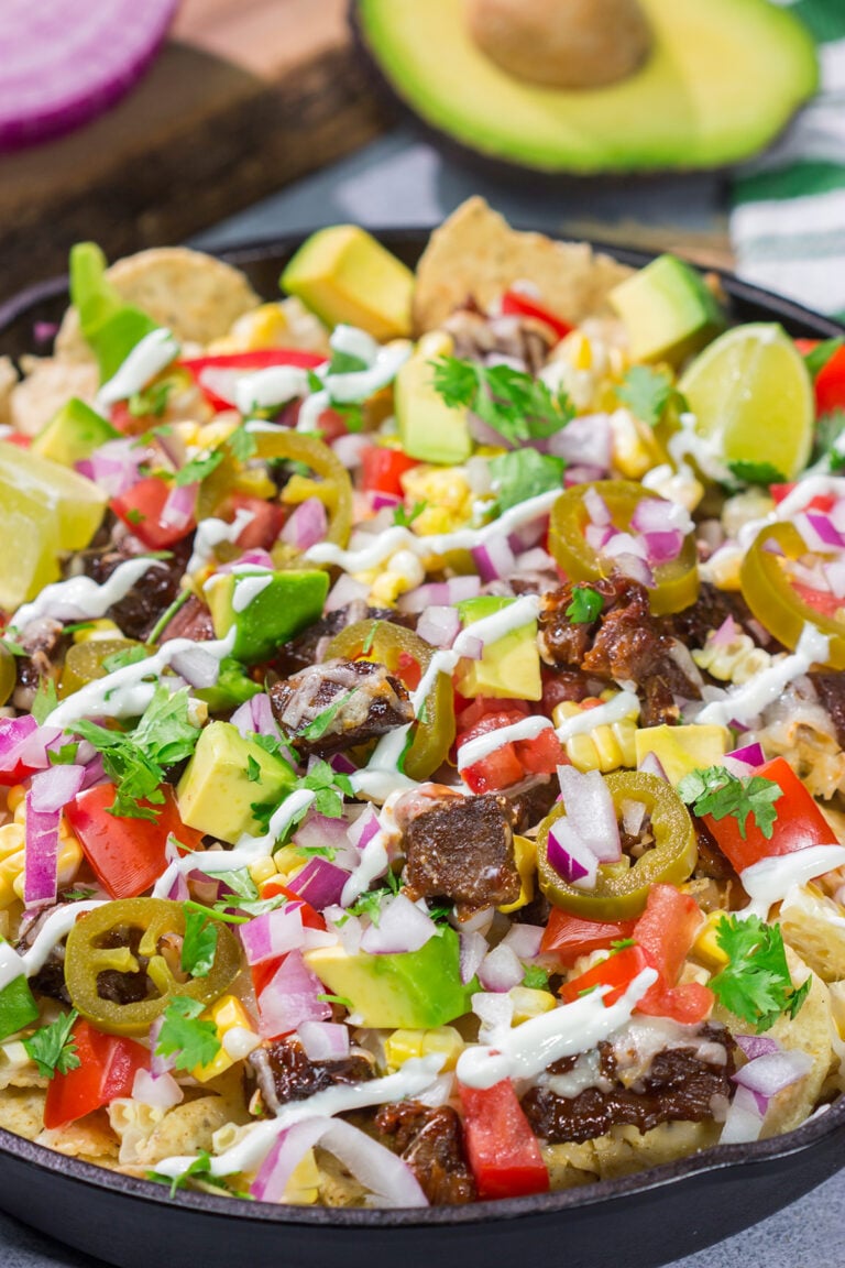 These Smoked Brisket Nachos are a great gameday appetizer! Crunchy tortilla chips topped with shredded cheese, smoked brisket and your favorite nacho toppings...yum!