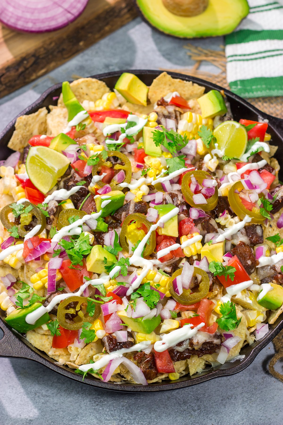 These Smoked Brisket Nachos are a great gameday appetizer! Crunchy tortilla chips topped with shredded cheese, smoked brisket and your favorite nacho toppings...yum!