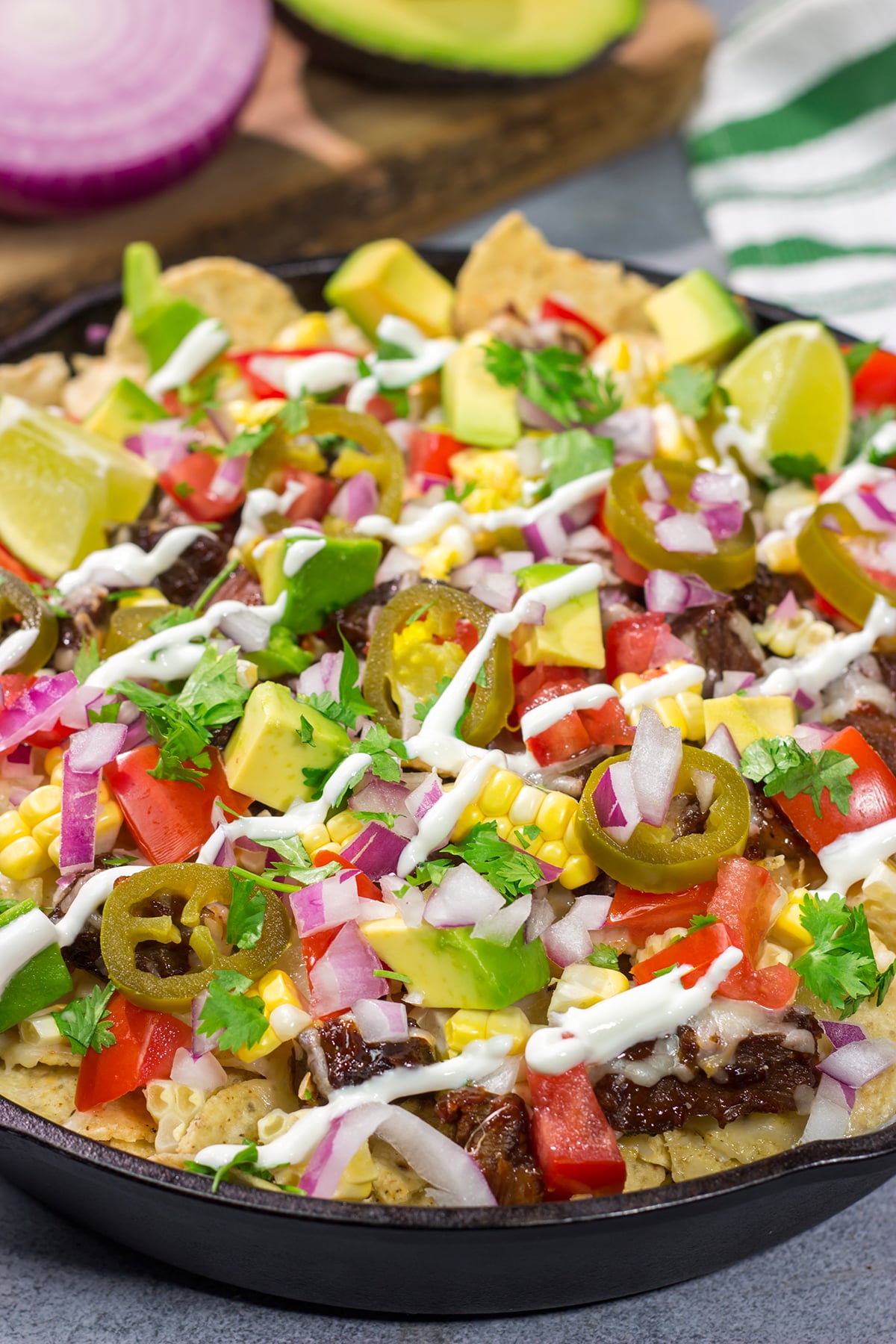 These Smoked Brisket Nachos are a great gameday appetizer! Crunchy tortilla chips topped with shredded cheese, smoked brisket and your favorite nacho toppings...yum!