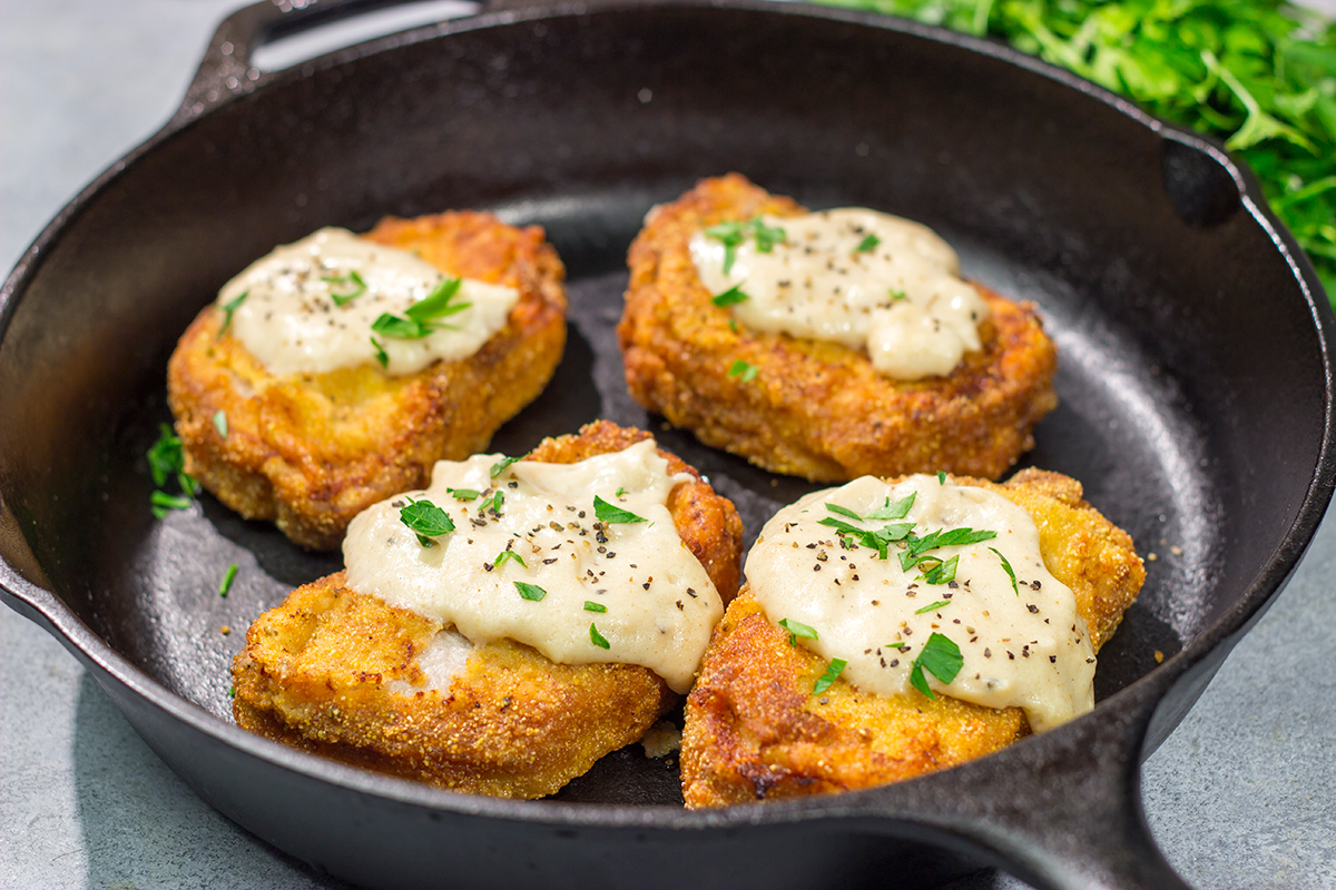 Fried Pork Chops are a classic Southern comfort food! These crispy, tender pork chops are served with an easy homemade gravy on top for maximum flavor.