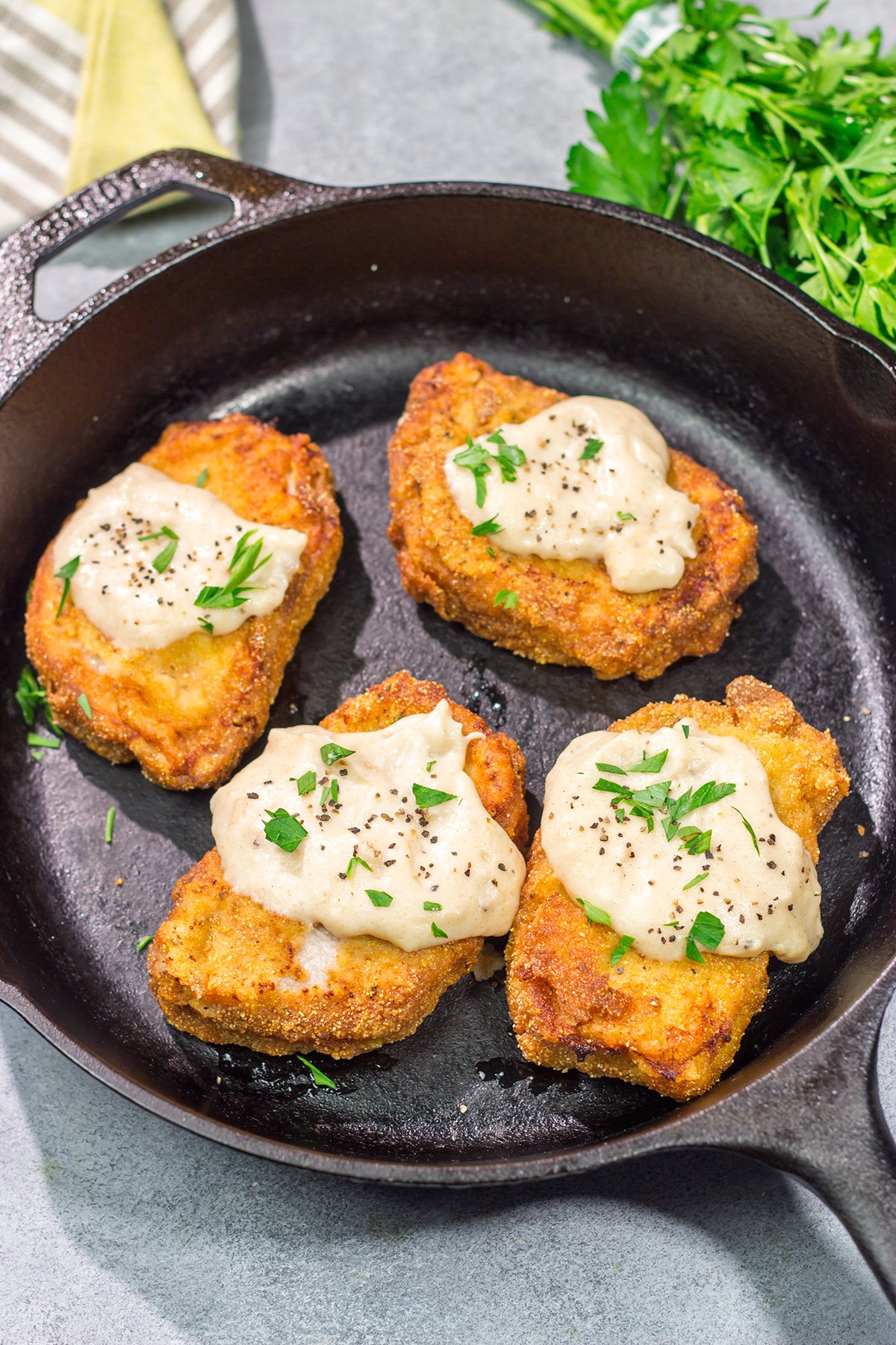 Fried Pork Chops are a classic Southern comfort food! These crispy, tender pork chops are served with an easy homemade gravy on top for maximum flavor.