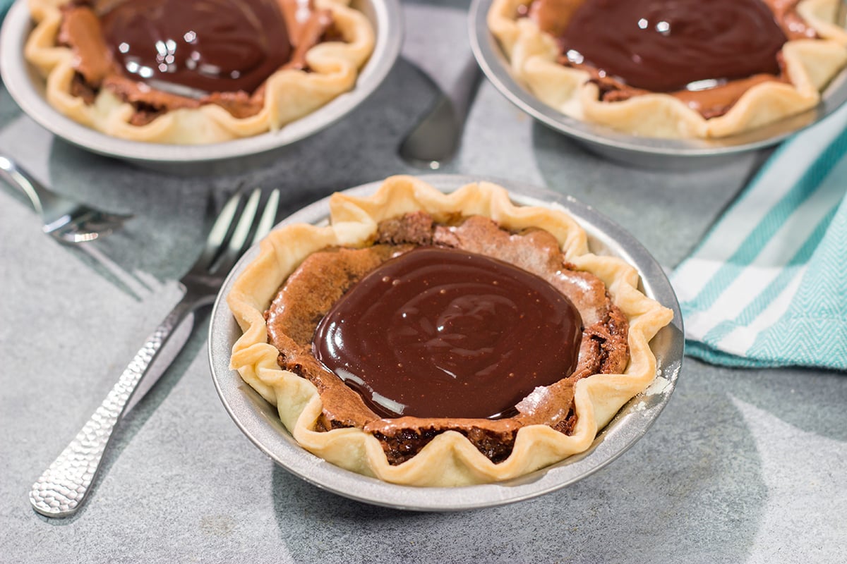 These Mini Fudge Pies are perfect for all chocolate lovers! These pies feature a chocolate chess filling topped with decadent chocolate ganache. Yum!!