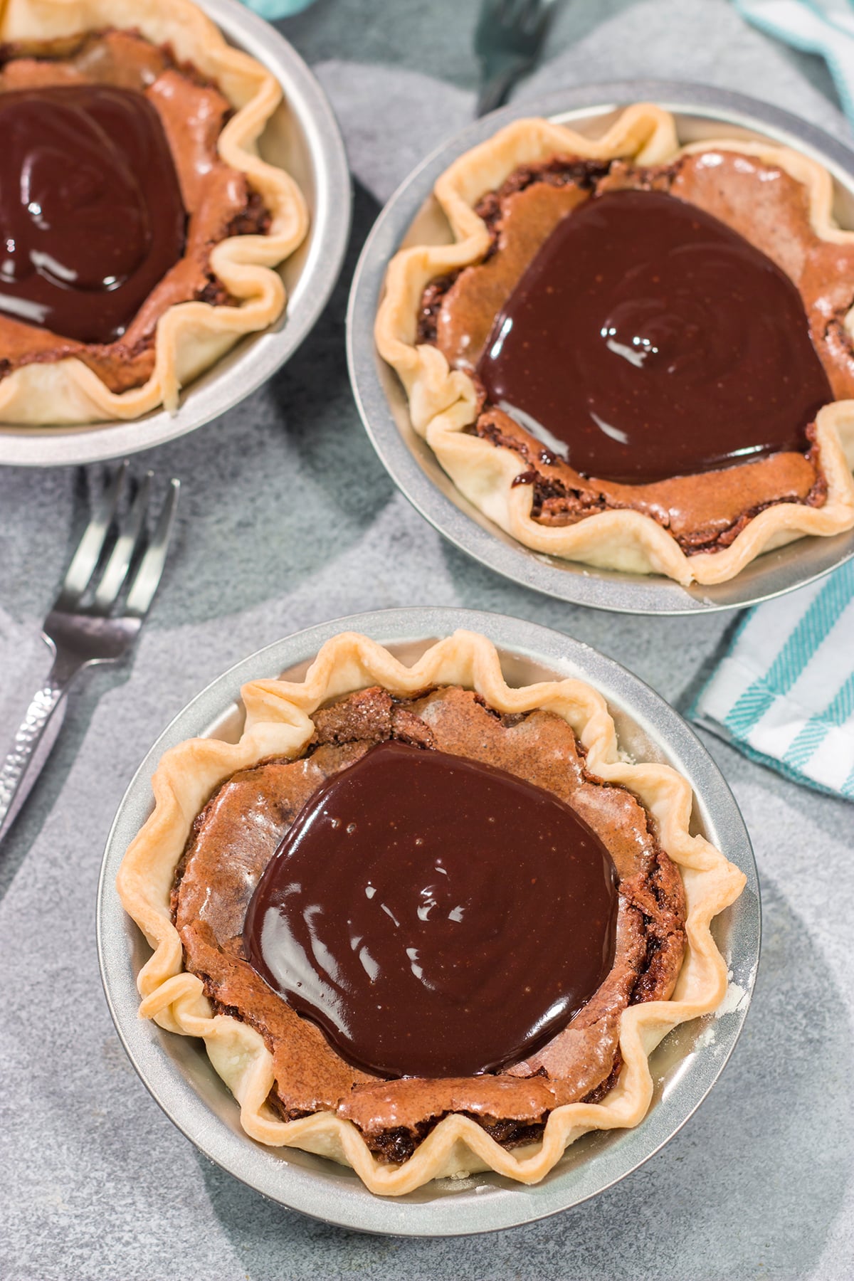 These Mini Fudge Pies are perfect for all chocolate lovers! These pies feature a chocolate chess filling topped with decadent chocolate ganache. Yum!!