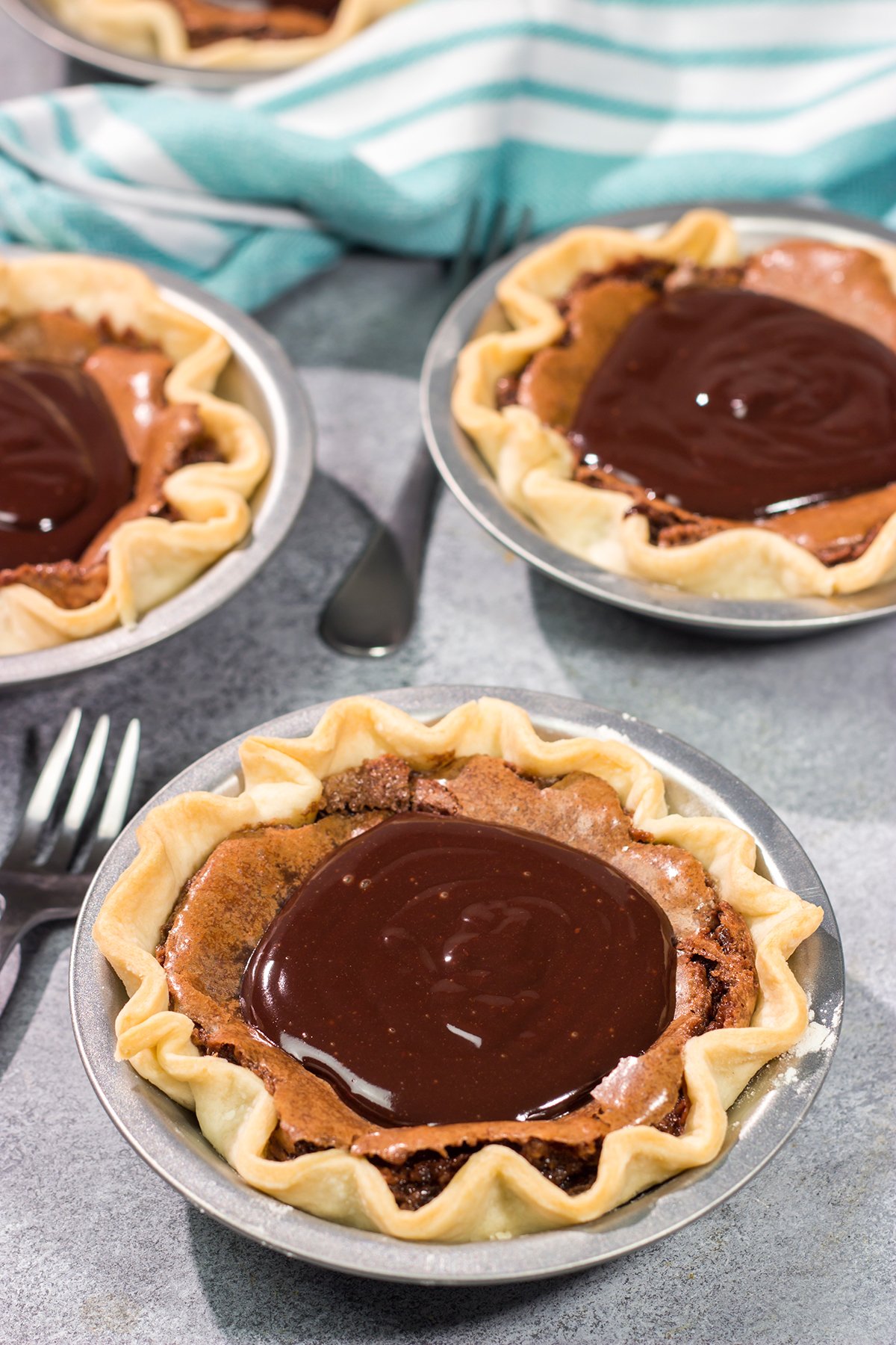 These Mini Fudge Pies are perfect for all chocolate lovers! These pies feature a chocolate chess filling topped with decadent chocolate ganache. Yum!!