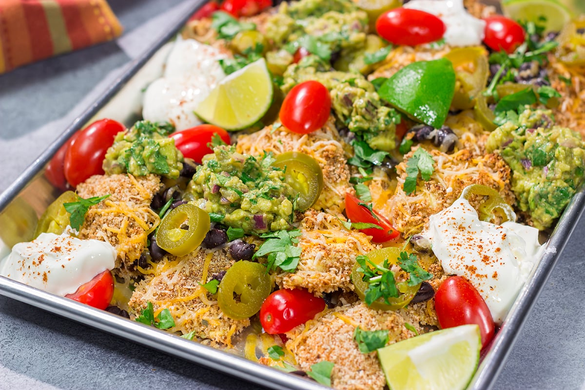 Skip the chips! These Toasted Ravioli Nachos feature all of your favorite nacho toppings on top of toasted ravioli. Go ahead and make an extra batch...you'll need it!