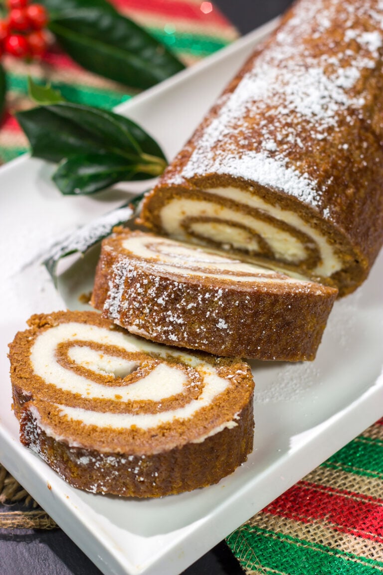 Get into the holiday spirit with this Gingerbread Cake Roll! This festive dessert features a thin gingerbread cake filled with a light and fluffy cream cheese frosting - it's perfect for holiday parties!