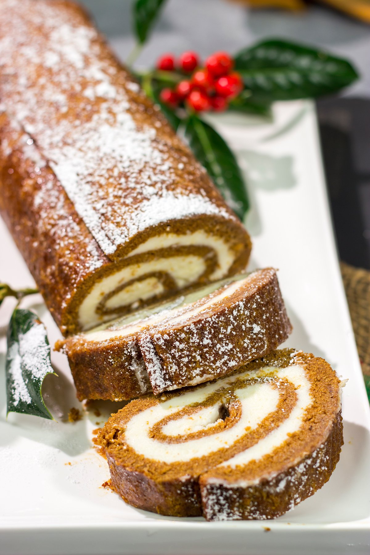 Get into the holiday spirit with this Gingerbread Cake Roll! This festive dessert features a thin gingerbread cake filled with a light and fluffy cream cheese frosting - it's perfect for holiday parties!