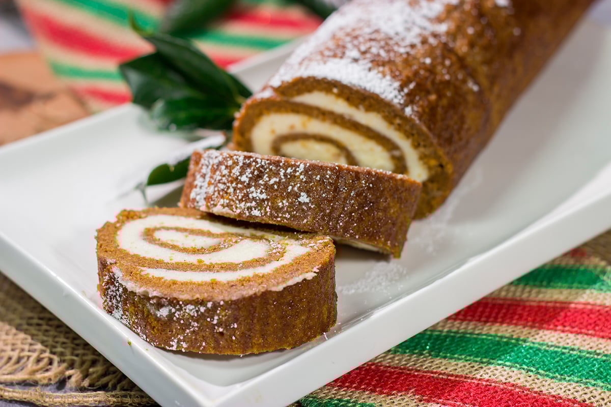Get into the holiday spirit with this Gingerbread Cake Roll! This festive dessert features a thin gingerbread cake filled with a light and fluffy cream cheese frosting - it's perfect for holiday parties!