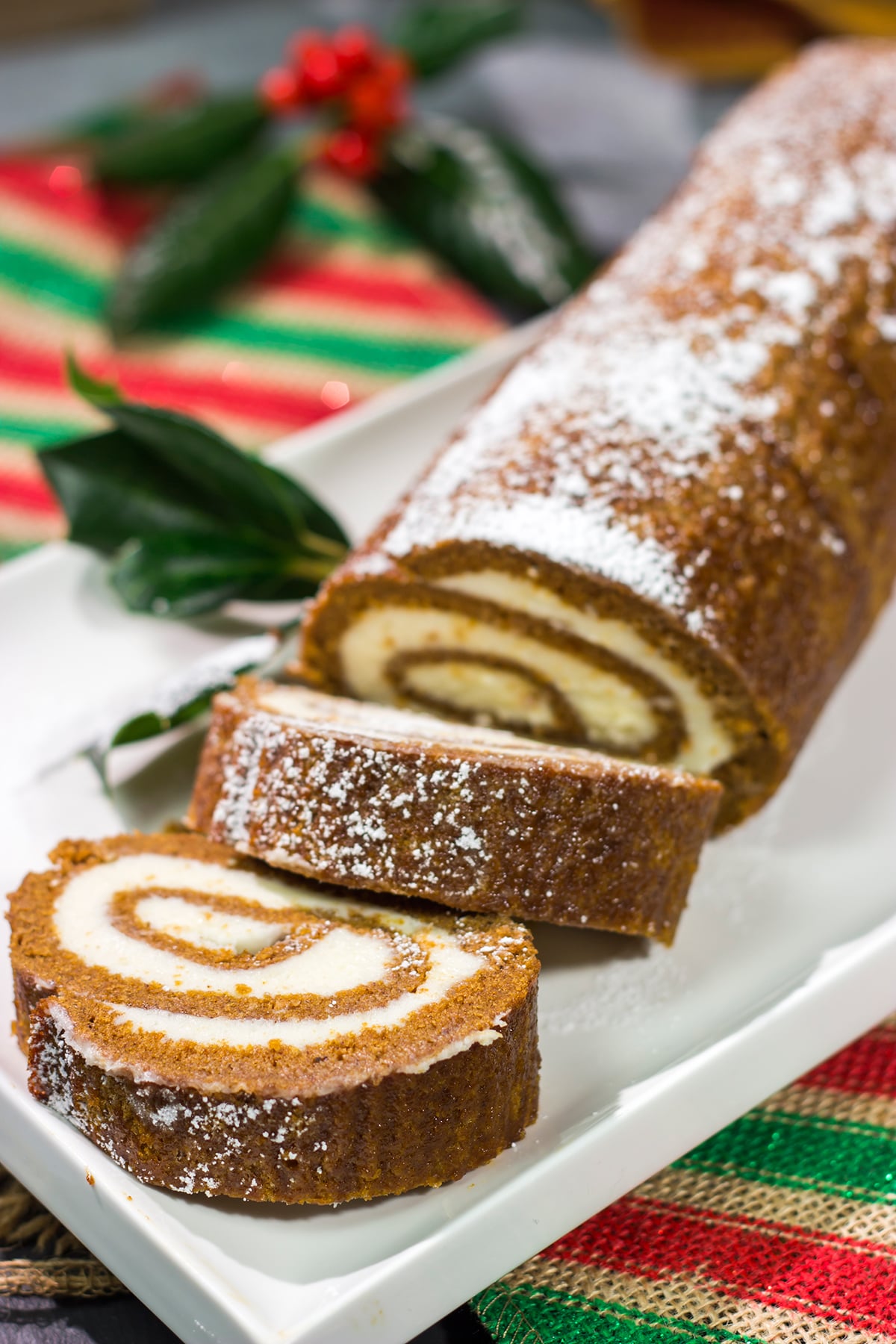 Get into the holiday spirit with this Gingerbread Cake Roll! This festive dessert features a thin gingerbread cake filled with a light and fluffy cream cheese frosting - it's perfect for holiday parties!