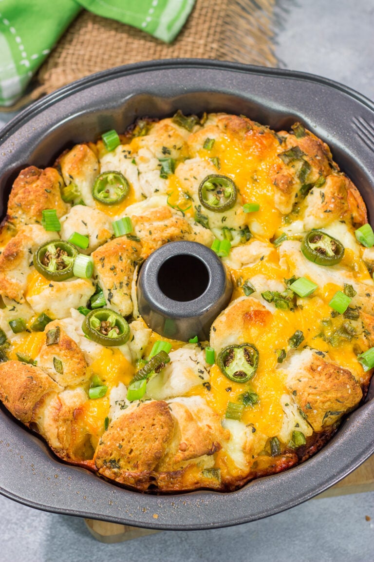 A warm loaf of this Jalapeno Cheddar Monkey Bread will be an instant favorite! This bread combines gooey melted cheese with fresh herbs and diced jalapenos - it's the ultimate comfort food.