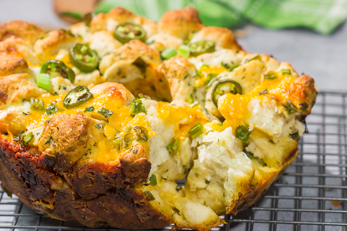A warm loaf of this Jalapeno Cheddar Monkey Bread will be an instant favorite! This bread combines gooey melted cheese with fresh herbs and diced jalapenos - it's the ultimate comfort food.