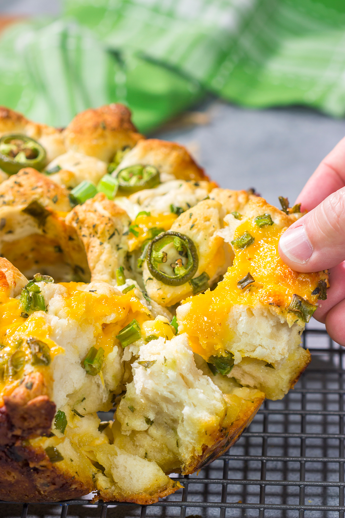 A warm loaf of this Jalapeno Cheddar Monkey Bread will be an instant favorite! This bread combines gooey melted cheese with fresh herbs and diced jalapenos - it's the ultimate comfort food.