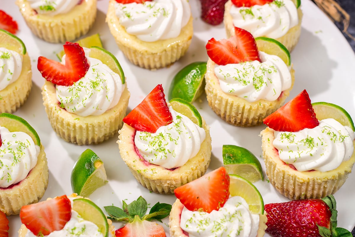 Featuring a splash of tequila and a swirl of fresh strawberry puree, these Mini Strawberry Margarita Cheesecakes are the perfect dessert for summer celebrations!