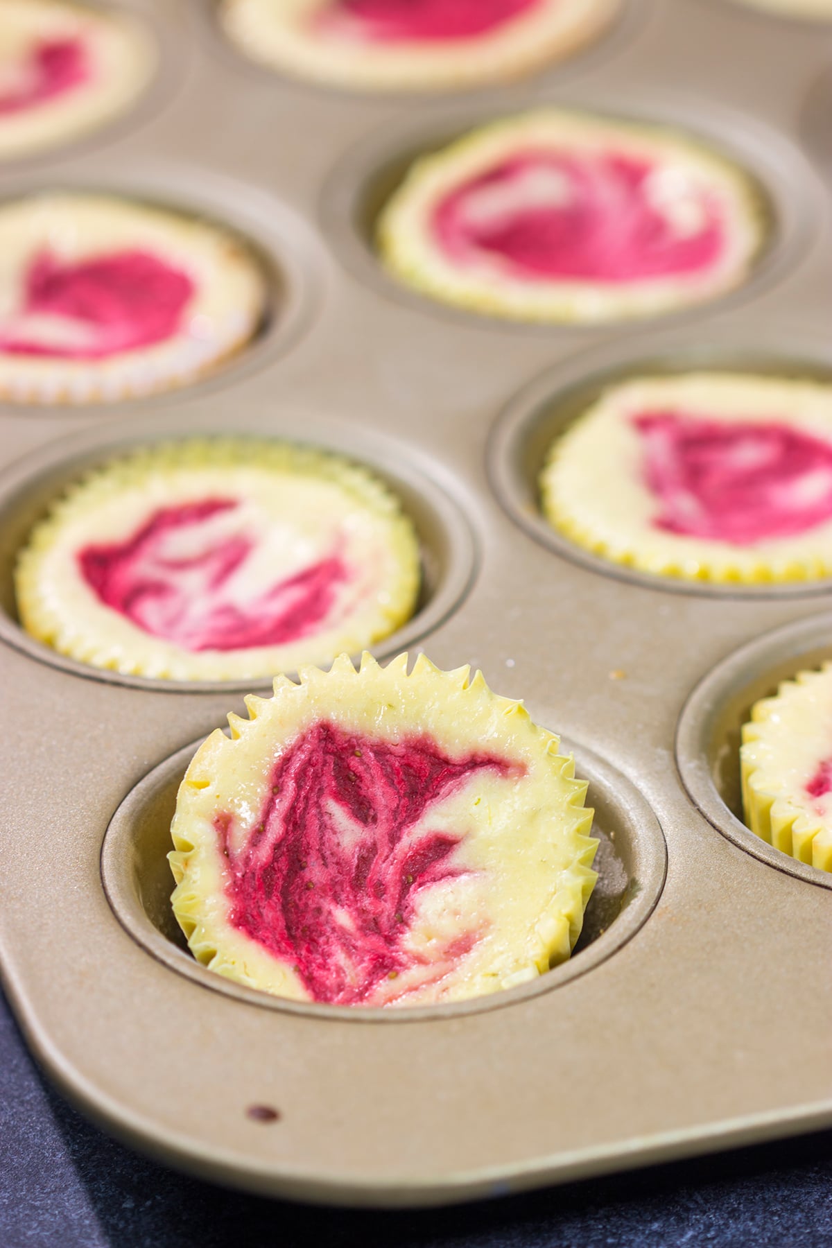 Featuring a splash of tequila and a swirl of fresh strawberry puree, these Mini Strawberry Margarita Cheesecakes are the perfect dessert for summer celebrations!
