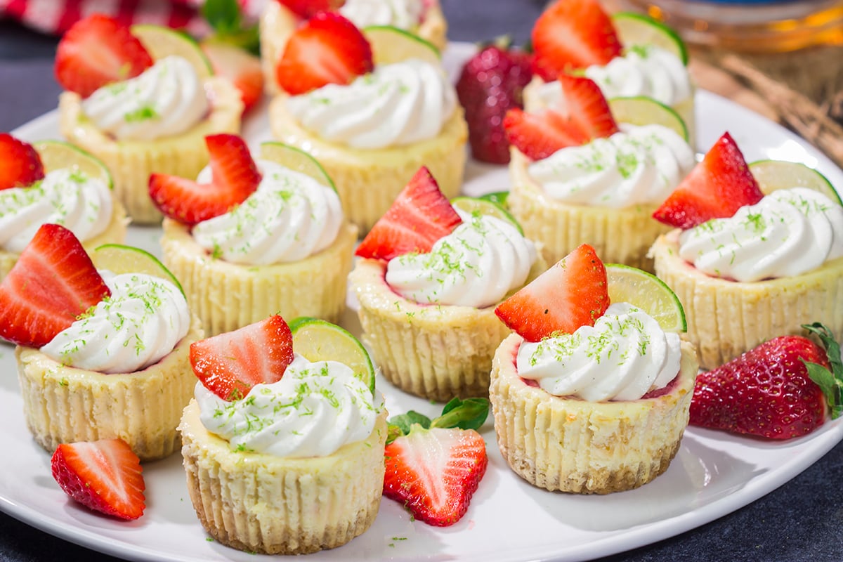 Featuring a splash of tequila and a swirl of fresh strawberry puree, these Mini Strawberry Margarita Cheesecakes are the perfect dessert for summer celebrations!