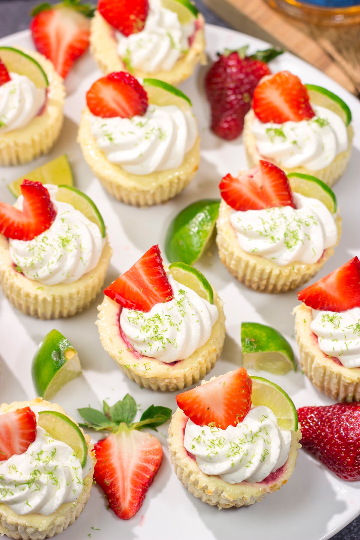 Featuring a splash of tequila and a swirl of fresh strawberry puree, these Mini Strawberry Margarita Cheesecakes are the perfect dessert for summer celebrations!