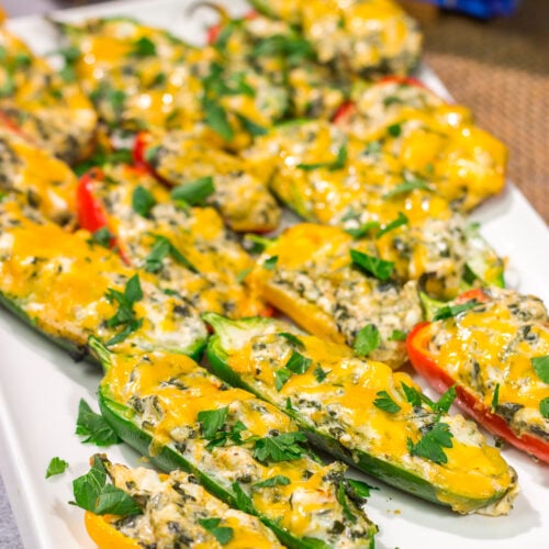 These Grilled Spinach Dip Stuffed Jalapenos feature peppers stuffed with creamy homemade spinach dip and topped with cheddar cheese. They're a delicious appetizer for summer grilling!