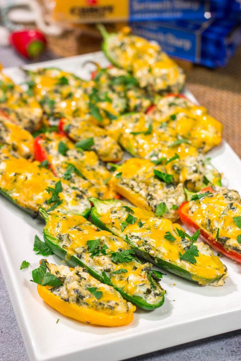These Grilled Spinach Dip Stuffed Jalapenos feature peppers stuffed with creamy homemade spinach dip and topped with cheddar cheese. They're a delicious appetizer for summer grilling!