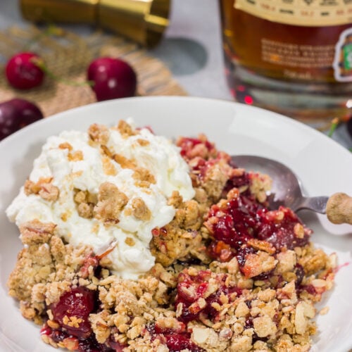 This Homemade Cherry Crisp is a simple dessert that the whole family will love. The homemade cherry filling gets topped with a crispy oat streusel...and a dollop of bourbon whipped cream!
