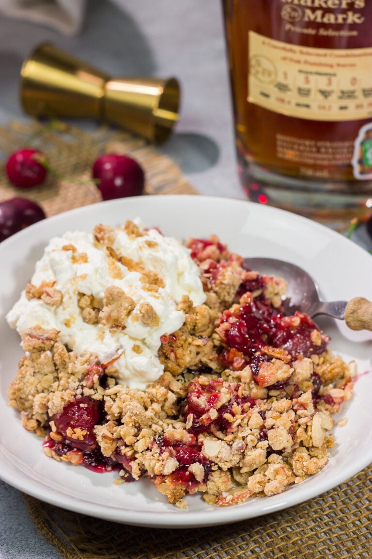 This Homemade Cherry Crisp is a simple dessert that the whole family will love. The homemade cherry filling gets topped with a crispy oat streusel...and a dollop of bourbon whipped cream!