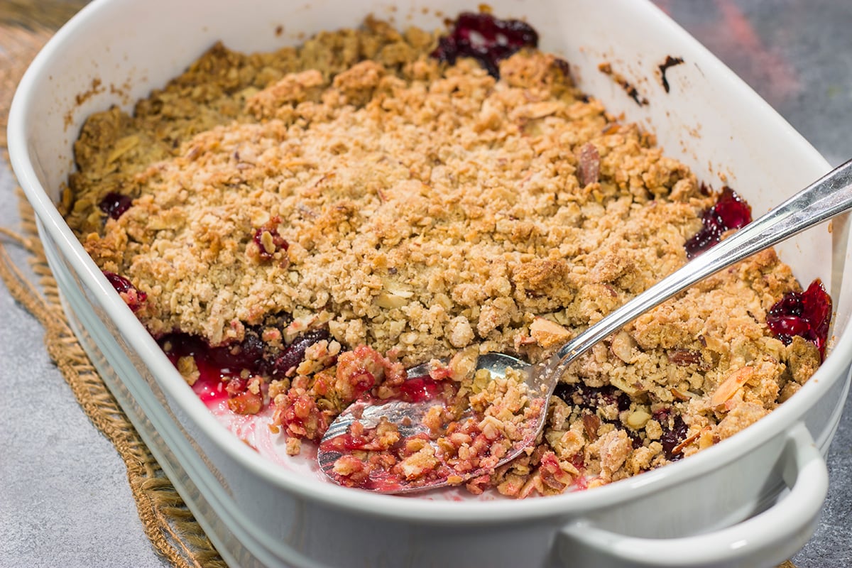 This Homemade Cherry Crisp is a simple dessert that the whole family will love. The homemade cherry filling gets topped with a crispy oat streusel...and a dollop of bourbon whipped cream!