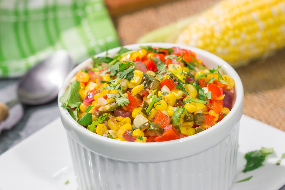 Featuring sweet corn and bell peppers combined with spicy jalapenos and tossed in lime butter, this Mexicali Corn recipe is a tasty side dish for summer meals!