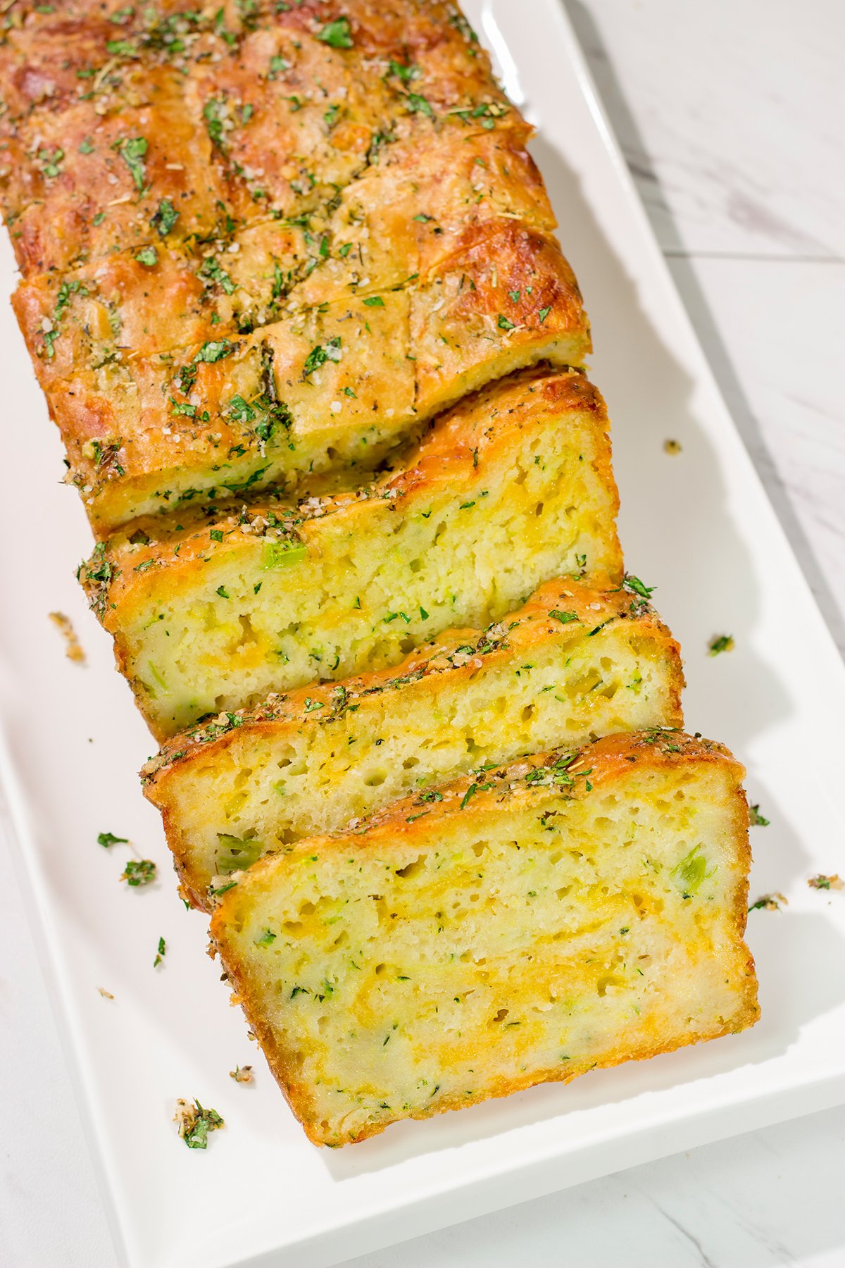 This Cheesy Zucchini Bread is packed with summer flavor! Toast up a slice of this savory quick bread and serve it next to salad or soup for an easy meal.