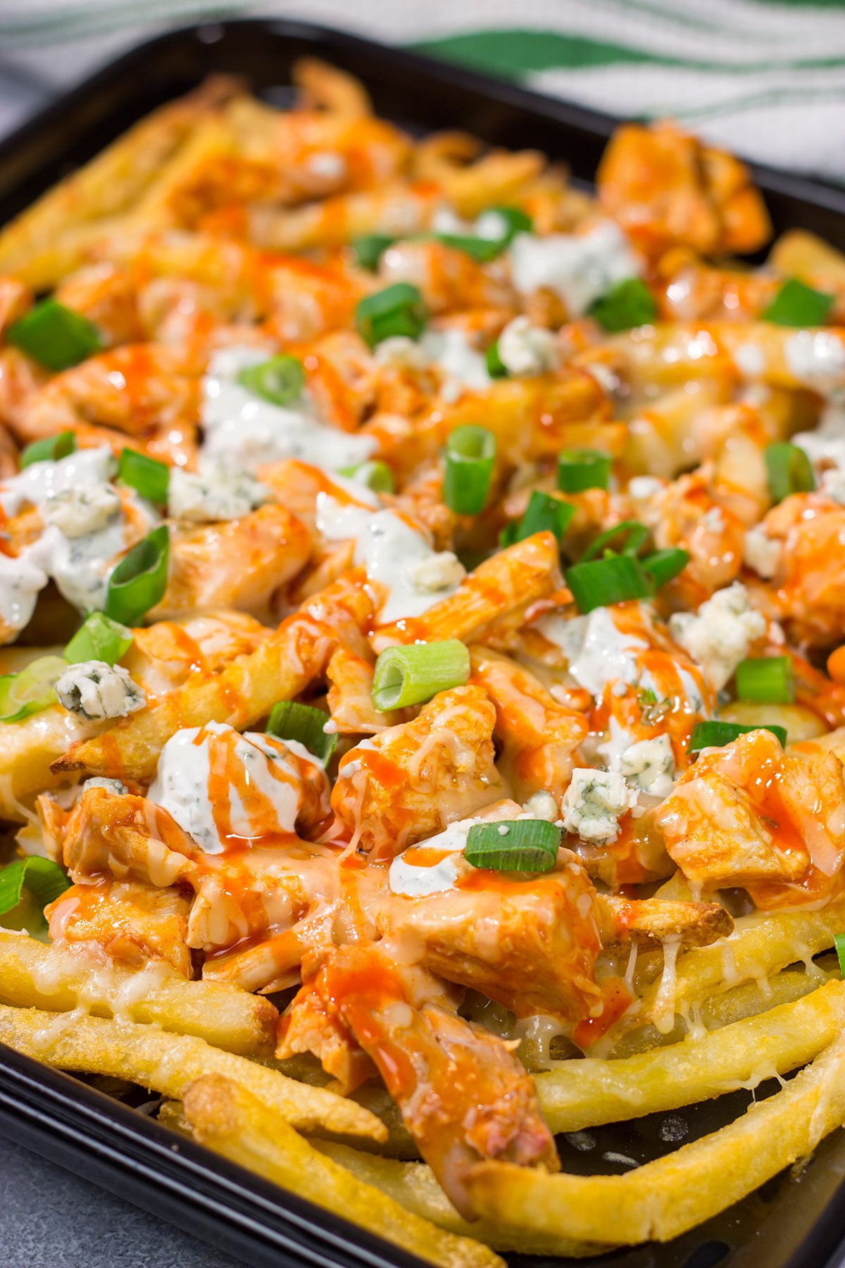 These Buffalo Chicken Cheese Fries are a fantastic gameday appetizer! The kick from the buffalo chicken combined with the creamy blue cheese dressing and melted cheese is a mouthwatering combo.