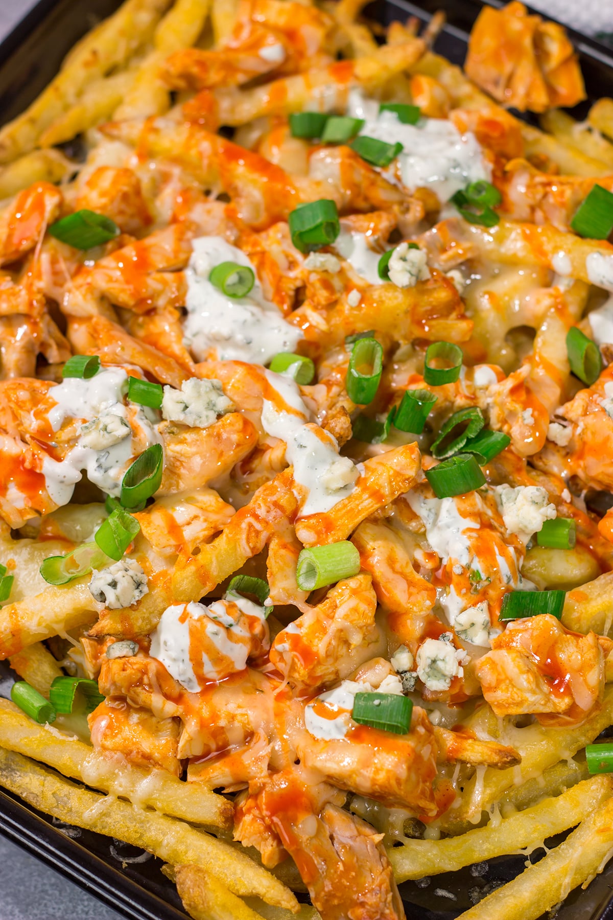 These Buffalo Chicken Cheese Fries are a fantastic gameday appetizer! The kick from the buffalo chicken combined with the creamy blue cheese dressing and melted cheese is a mouthwatering combo.