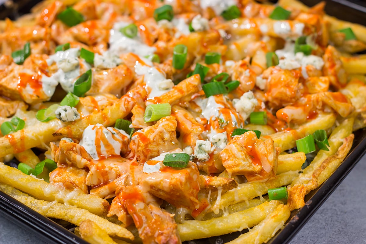 These Buffalo Chicken Cheese Fries are a fantastic gameday appetizer! The kick from the buffalo chicken combined with the creamy blue cheese dressing and melted cheese is a mouthwatering combo.