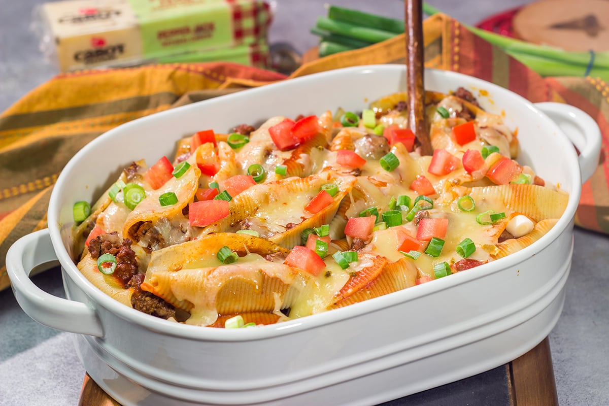 Put a spin on taco night with these Cheesy Taco Stuffed Shells! Instead of tortillas, stuff seasoned taco meat into pasta shells and top it with plenty of melty cheese for a fun family dinner.